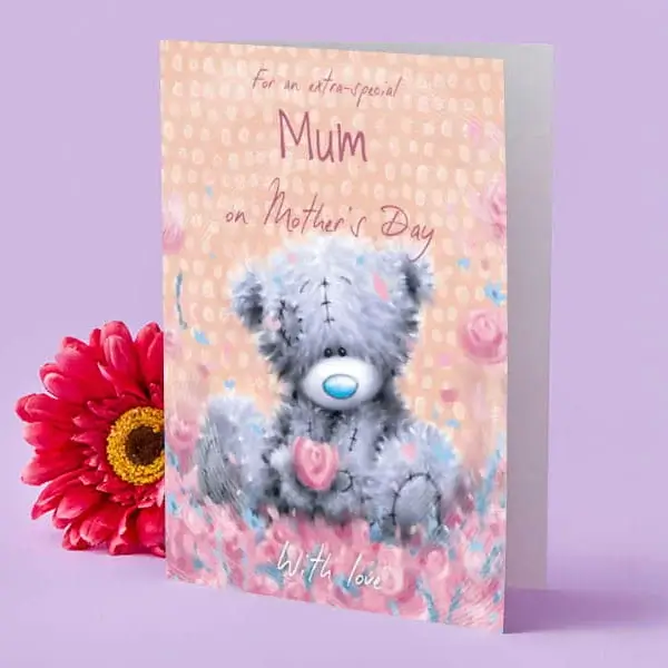 A collection of metallic balloons against a pink background, including two gold star-shaped balloons, a black round balloon with gold lettering that reads Happy Birthday, and a black champagne bottle-shaped balloon with gold accents and the words Pop Clink Fizz.